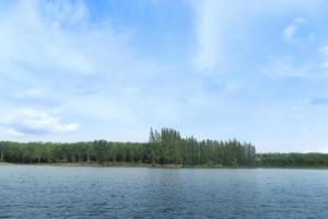 Landscape view of nature Reservoir with light waves. Along the wooden bridge is far away in the tourist attraction. with green trees for backgound under blue sky. photo