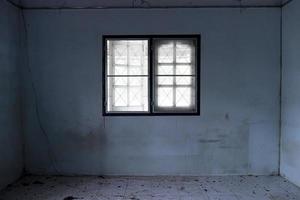 ventana dentro de la casa con el ambiente de la casa que está sucio y oscuro. edificios abandonados. foto