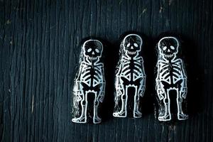 Halloween skeleton candy on dark wood photo