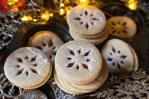 Christmas Linzer cookies with red filling and holiday lights photo