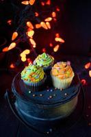 Halloween cupcakes with sprinkles in spooky lights setting photo