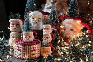 Collection of Christmas Santa mugs in holiday setting photo