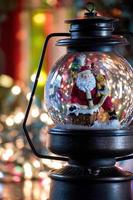 snow globe with Santa and snow flakes in festive bokeh setting photo