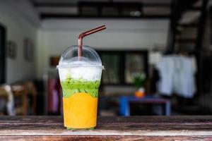 Iced mocha or green tea in plastic cup on wood table in the cafe. photo