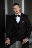 portrait of the groom in a brown three-piece suit photo