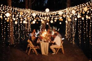 cena familiar de bodas por la noche en el bosque foto