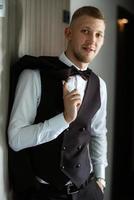 portrait of the groom in a brown three-piece suit photo