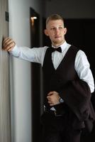 portrait of the groom in a brown three-piece suit photo