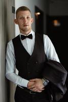 portrait of the groom in a brown three-piece suit photo