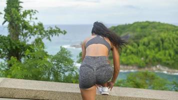 una hermosa mujer en forma en ropa deportiva haciendo ejercicio en el pico de la montaña junto al mar, concepto de salud y viaje. foto