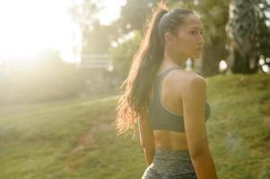 retrato de una hermosa mujer en forma usando ropa deportiva en el concepto de parque, salud y deporte. foto