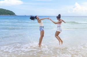 Two women enjoying and relaxing on the beach,  Summer, vacation, holidays. photo