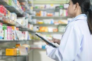 retrato de una farmacéutica que usa una tableta en una farmacia moderna. foto