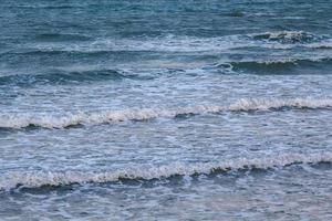 strong wind and ocean waves hit the shore. In the evening, the sea floor was blue, alternating with the grit of sand for a period that nature created, beautiful and scary. photo