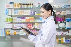 retrato de una farmacéutica que usa una tableta en una farmacia moderna. foto