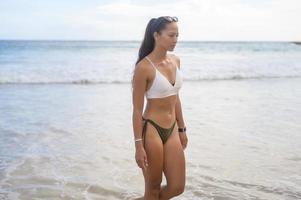 joven hermosa mujer en bikini disfrutando y relajándose en la playa, verano, vacaciones, vacaciones, concepto de estilos de vida. foto