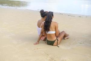 dos amigas atractivas en bikini disfrutando y relajándose en la playa, verano, vacaciones, vacaciones, concepto de estilos de vida. foto