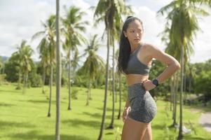 Portrait of Beautiful fit woman wearing sportswear in tropical park, Health and sport concept. photo