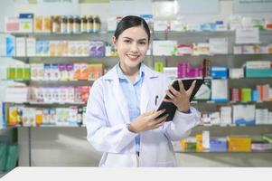 retrato de una farmacéutica que usa una tableta en una farmacia moderna. foto