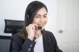 Female call center agent with headset consulting clients online, customer service and customer support operator concept photo