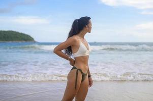 joven hermosa mujer en bikini disfrutando y relajándose en la playa, verano, vacaciones, vacaciones, concepto de estilos de vida. foto