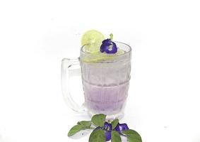 Purple Butterfly Pea Flower Water or Butterfly Pea Flower Tea with Honey and Lemon is a healthy herbal water with beta-carotene on a white background. photo