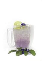 Purple Butterfly Pea Flower Water or Butterfly Pea Flower Tea with Honey and Lemon is a healthy herbal water with beta-carotene on a white background. photo