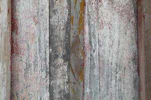 antigua puerta de madera durante más de ochenta años al sol y durante mucho tiempo se está deteriorando con el tiempo y el color se está despegando de la madera. foto