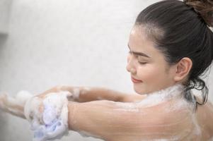 Happy beautiful woman is taking a shower photo