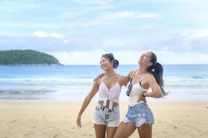 Two women enjoying and relaxing on the beach,  Summer, vacation, holidays. photo