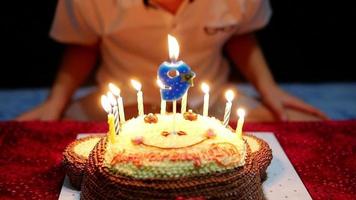 el niño está felizmente soplando velas en su pastel de cumpleaños