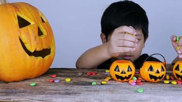 Little kid playing jack o lantern clay and candy in Halloween festival video