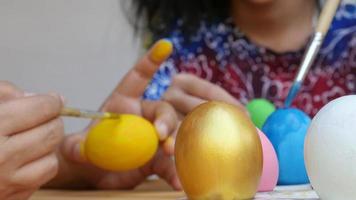 pessoas pintando ovos de páscoa coloridos - conceito de celebração do feriado de páscoa video