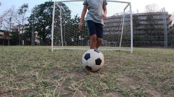 Boy is playing soccer football in green field - people with outdoor sport winner goal target success concep video