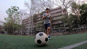 Boy is playing soccer football in green field - people with outdoor sport winner goal target success concept video