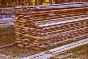 Processed lumber on the background of the autumn landscape. photo