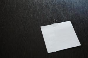 White paper pad on black wooden table . space for text photo