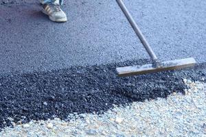 asphalt road surface under construction has gravel joints, with a black and gray background as a vertical and horizontal image. photo