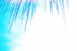 White icicles against the blue winter sky. photo