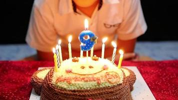 el niño está felizmente soplando velas en su pastel de cumpleaños video