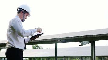 homem verificando fazenda de painéis de células solares - engenharia elétrica trabalhando no conceito de pátio de plantas de células solares video