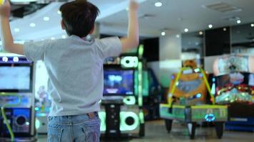 crianças felizes em jogar jogos de arcade na terra dos brinquedos - desfocar o fundo divertido jogar terra na recreação da cidade do jogo de arcade indoor video