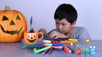 Little kid playing jack o lantern clay and candy in Halloween festival video