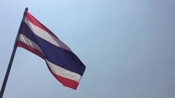 Slow motion of Thailand flag pole moving in blowing wind over bright blue sunny sky - nation flag freedom concept video