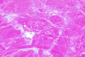 Defocus blurred pink watercolor in swimming pool rippled water detail background. Water splash, water spray background. photo