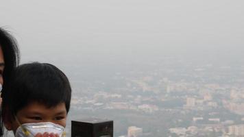 Mom and son depressed suffer from air pollution over city scape dirty air background - Chiang Mai Thailand city smoke air PM2.5 pollution concept video