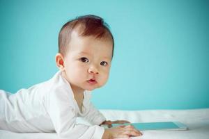recién nacido asiático feliz con tableta digital, niño sano con nuevo concepto de familia foto