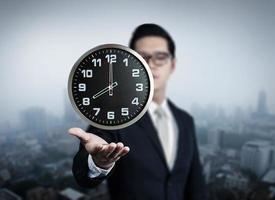 Businessman hand holding clock, new business in the city collection, studio shot photo