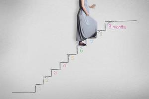 Pregnant woman walking up stair, The growth of the unborn child concept photo