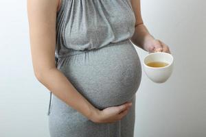 Pregnant woman drinking the hot tea photo